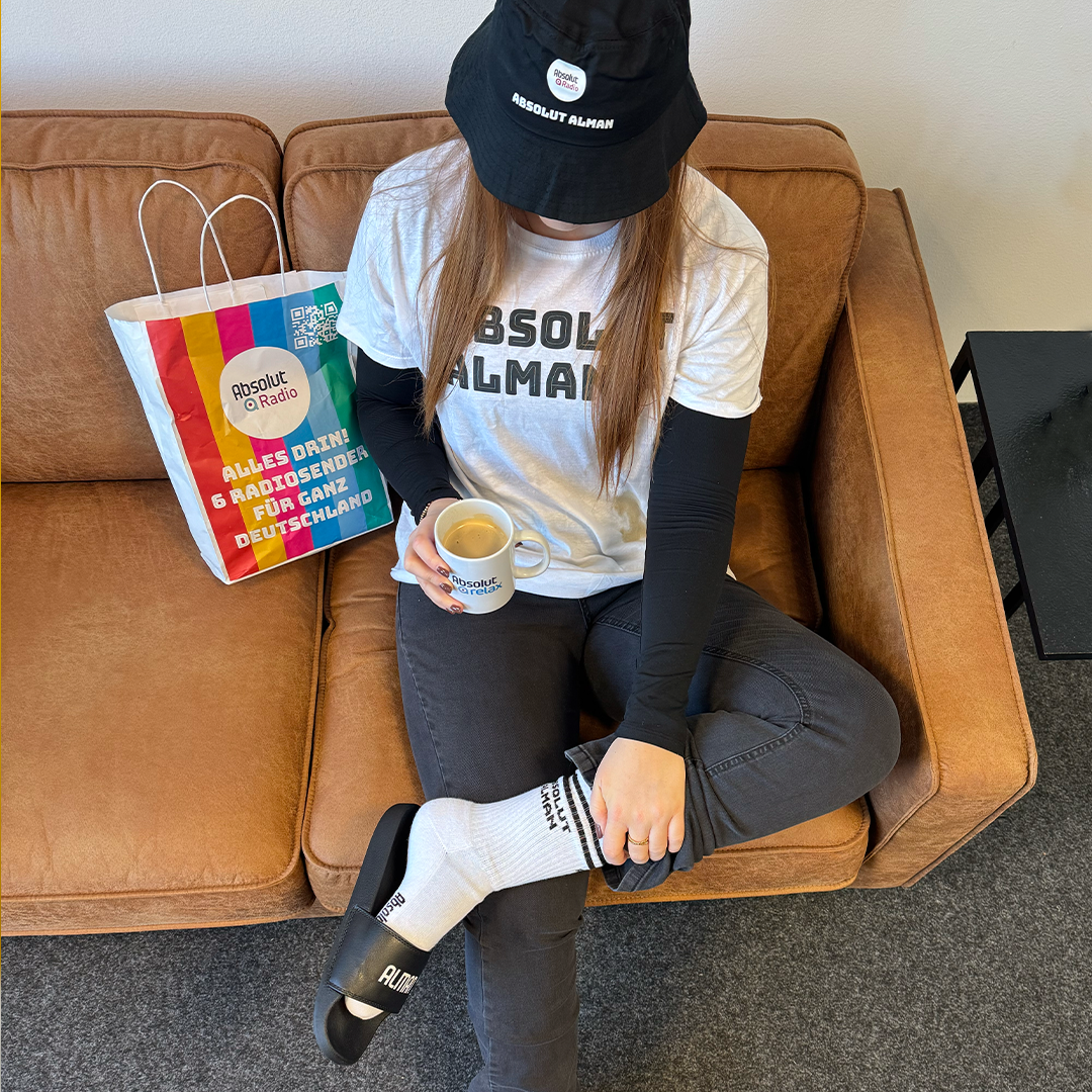 Mädchen sitzt auf einem Sofa und trägt Absolut-Radio-Merchandise
